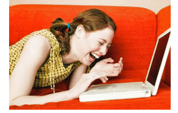 Девушка смеется за компьютером. Девушка за ноутбуком смеется. Девушка смеётся у компьютера. Девушки смеются за компом