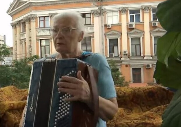 У центрі Києва 76-річна бабуся розважає містян грою на баяні зі свого балкона. || Фото: ТСН 
