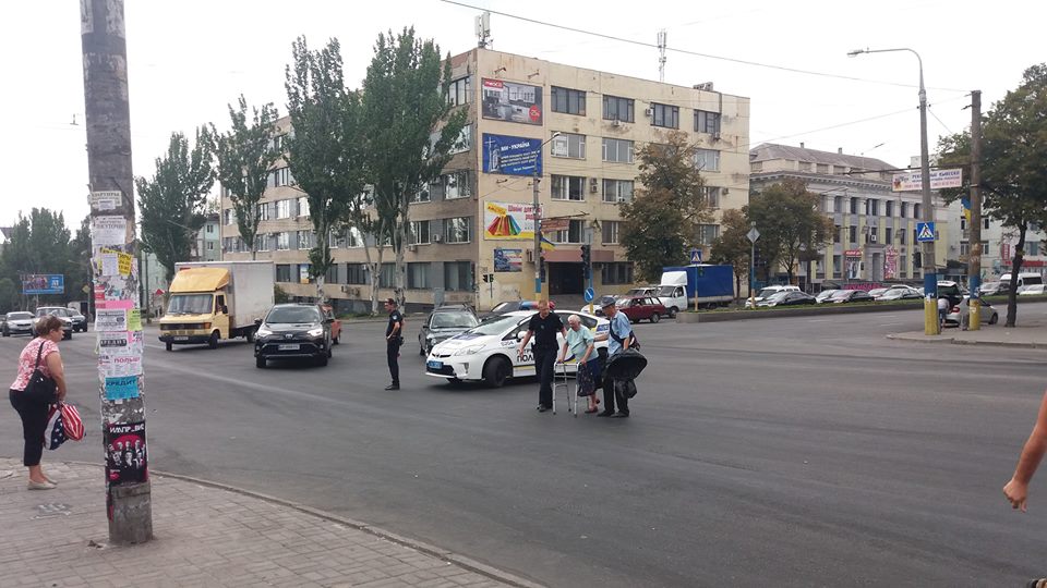 Полицейские перевели бабушку через дорогу, перекрыв движение. Фото: Олег Коломоец